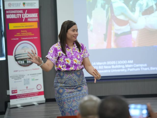 A speaker addressing the room beside an IFERP International Mobility Exchange Program banner