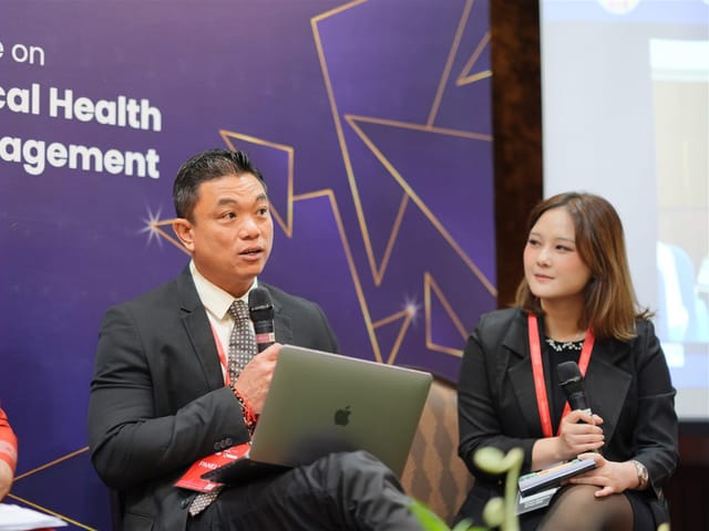 Panellists answering questions on stage during a conference panel discussion