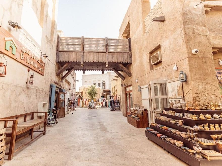 A narrow sand-coloured lane and wind tower in the Al Fahidi historical quarter