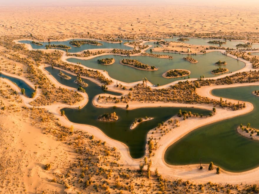 Al Qudra Lakes, blue water ringed by desert scrub and dunes